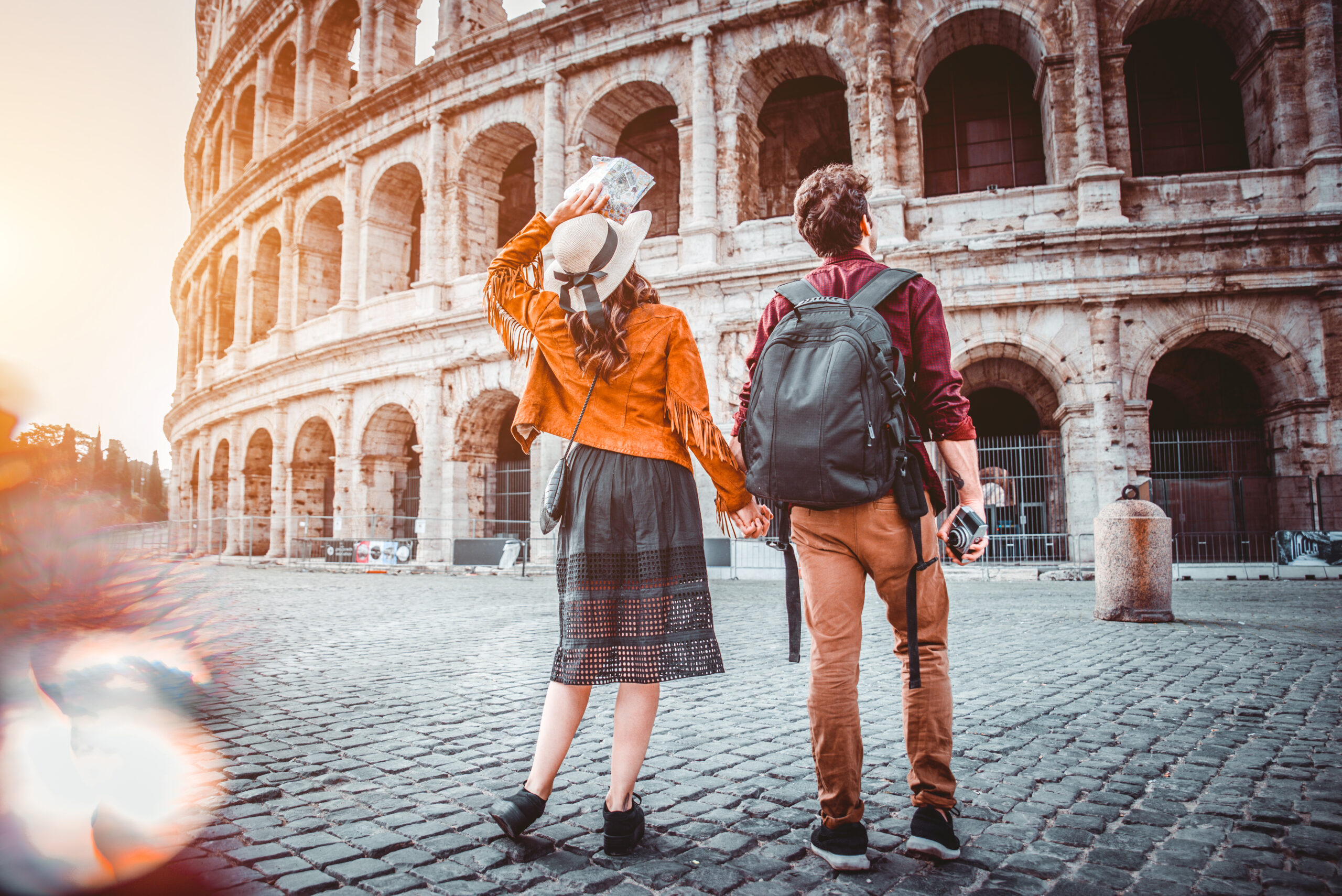 Young couple at the Colosseum, Rome - Happy tourists visiting italian famous landmarks