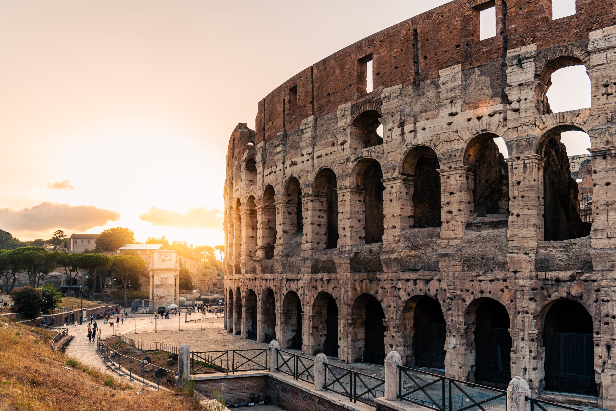 Outdoor view of The Colosseum or Coliseum with sun flare on background, also known as the Flavian Amphitheatre. It is an oval amphitheatre in the centre of Rome.