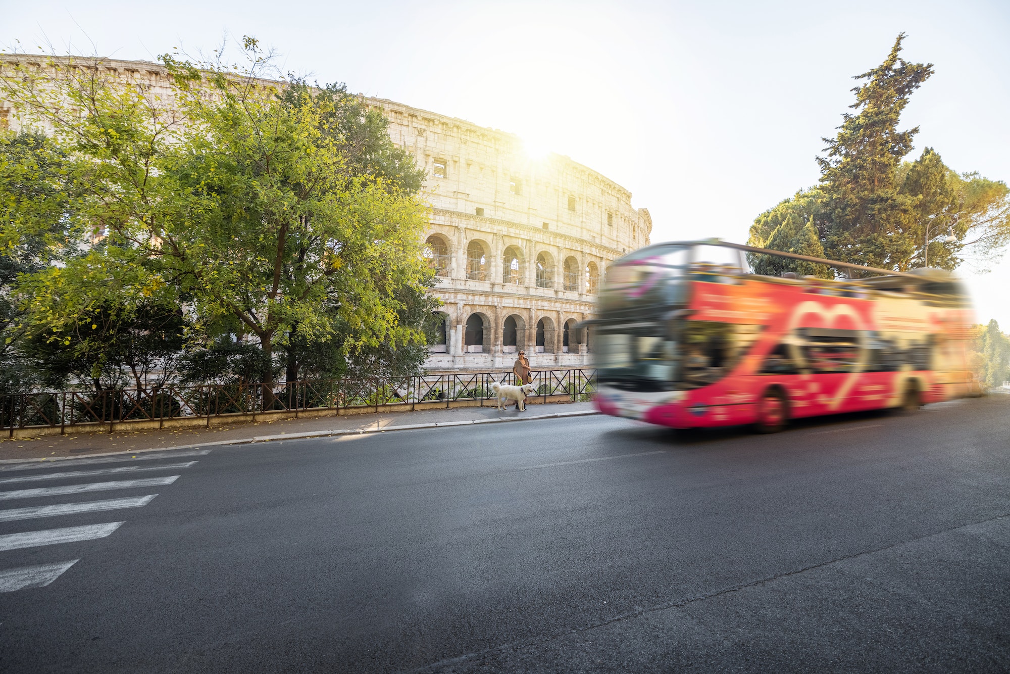 Street view with motion blurred tourist bus and Colosseum in Rome